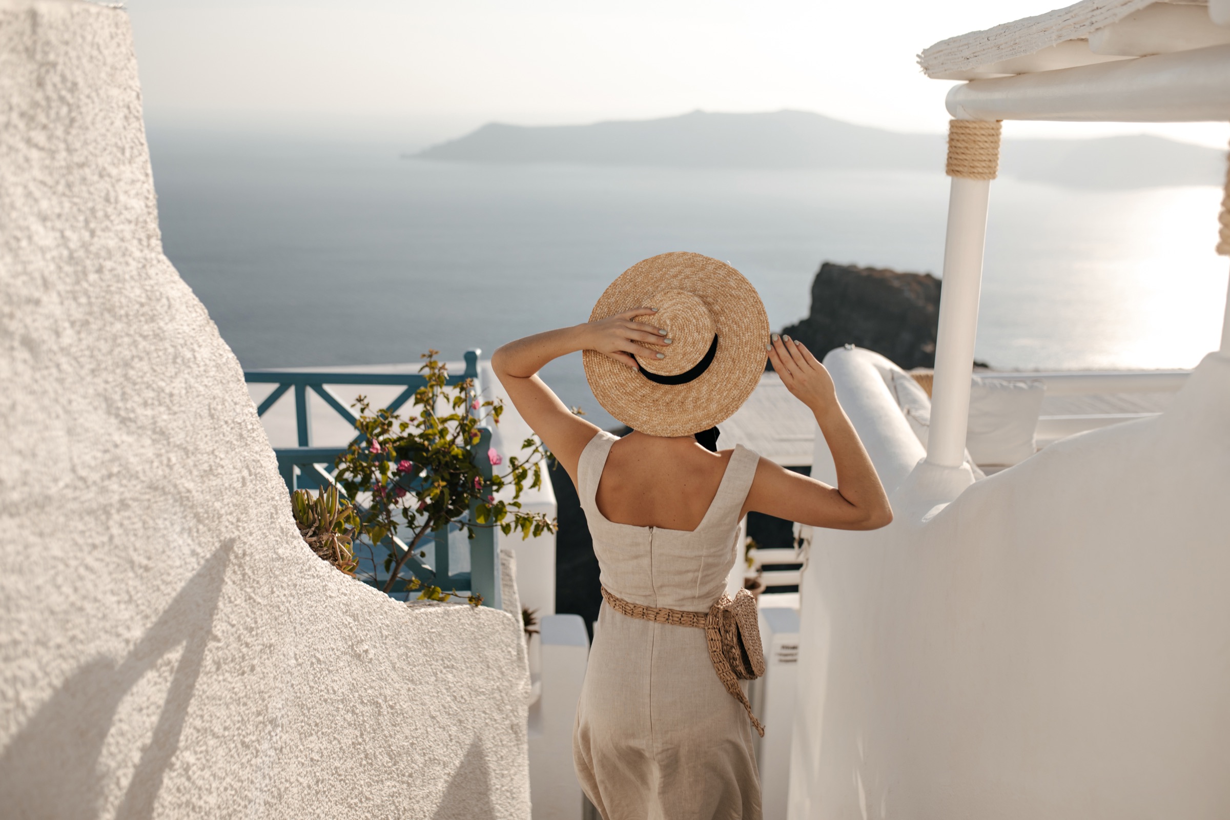 Guest walking through a white Greek island village toward the sea
